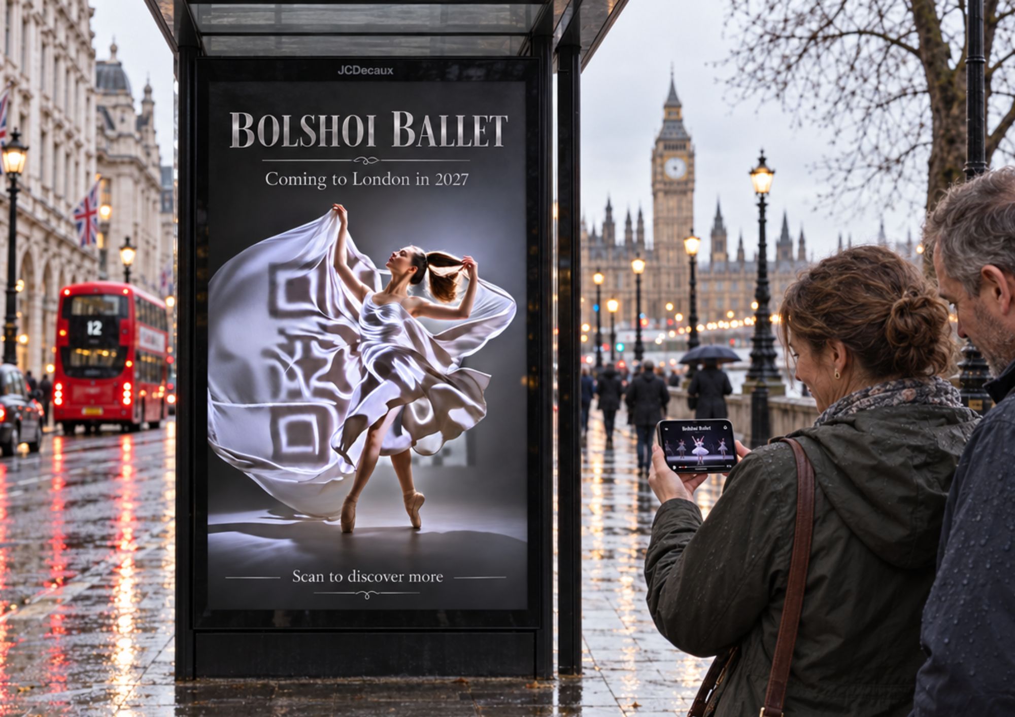 A woman scans a Bolshoi Ballet bus-shelter ad at a rainy London street corner near Big Ben with her phone, showing a preview of the ballet after scanning the StoryCode formed by the ballerina’s flowing white dress.